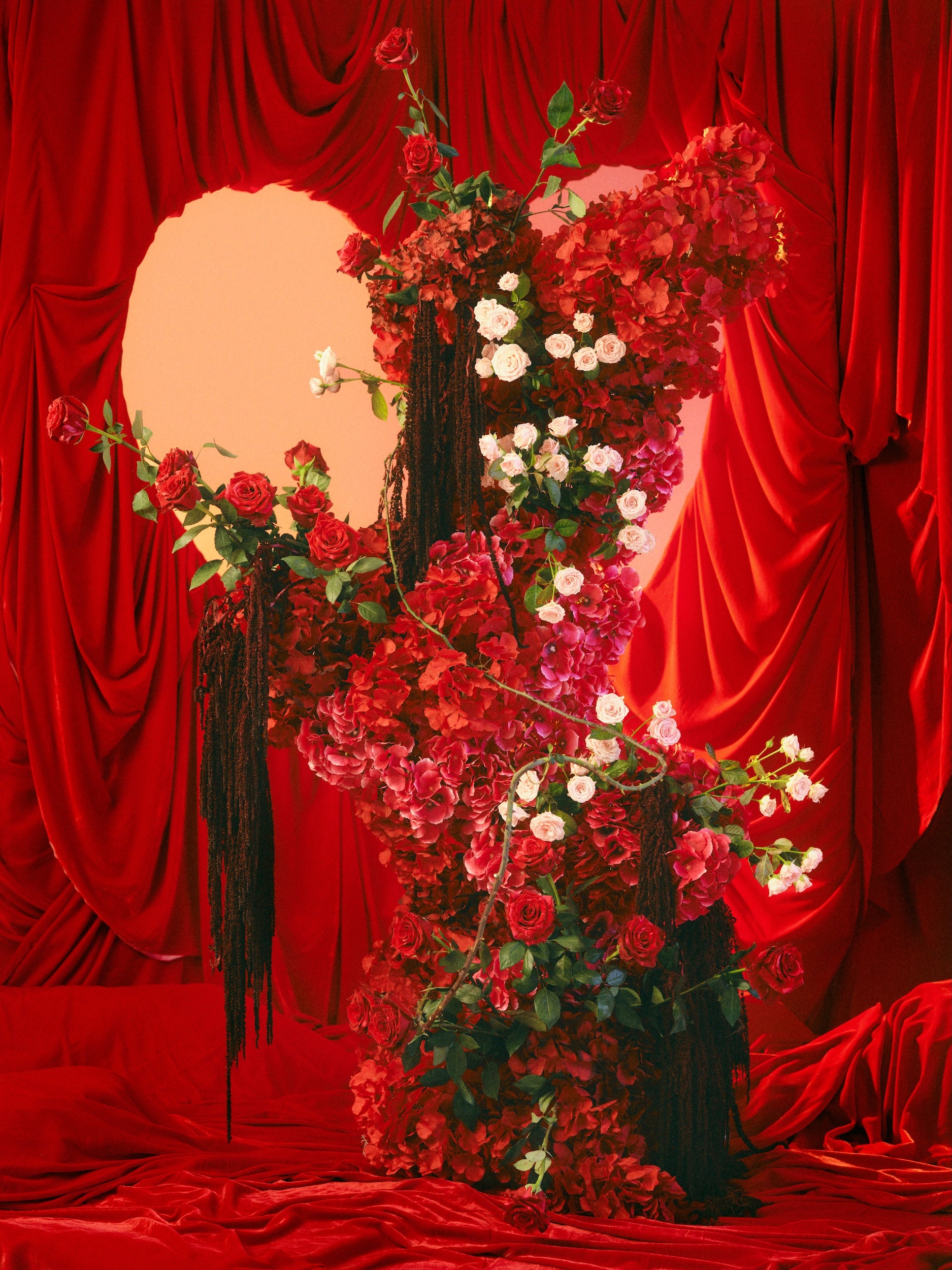 Valentines Floral arrangement in a vase against a red curtain backdrop