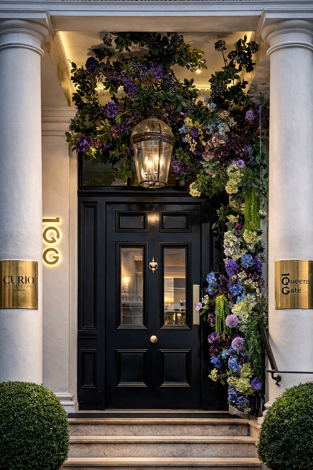 Decorative floral archway above a black door with gold accents on a building facade.