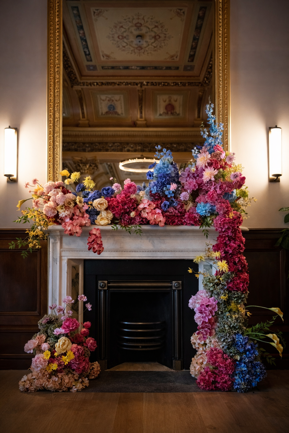 Decorative floral arrangement in front of a fireplace with ornate ceiling in the background